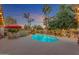 The perfectly landscaped backyard features a pool, lush greenery, and a dining area for outdoor entertaining and relaxation at 5837 E Presidio Rd, Scottsdale, AZ 85254