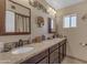 Bathroom featuring dual sinks, decorative mirrors, and granite countertops at 5837 E Presidio Rd, Scottsdale, AZ 85254