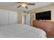 Bedroom with a ceiling fan, closet, dresser, and a large television at 5837 E Presidio Rd, Scottsdale, AZ 85254