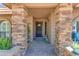 Close-up of a home's front entrance showcasing stone pillars, a decorated door, and a brick walkway at 5837 E Presidio Rd, Scottsdale, AZ 85254