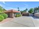 Single-story home showcasing desert landscaping, a detached garage, and a spacious driveway at 5837 E Presidio Rd, Scottsdale, AZ 85254