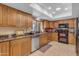 Traditional-style kitchen features tile floors, granite countertops, stainless steel appliances, and wood cabinets at 5837 E Presidio Rd, Scottsdale, AZ 85254