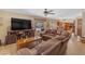 Cozy living room with leather furniture, a ceiling fan, tile floors, and a backyard view at 5837 E Presidio Rd, Scottsdale, AZ 85254