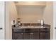 Stylish wet bar featuring granite countertops, dark cabinetry, and a convenient sink at 5837 E Presidio Rd, Scottsdale, AZ 85254