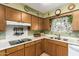 A functional kitchen featuring wood cabinets, white appliances, and laminate floors at 6337 E Evergreen St, Mesa, AZ 85205