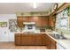Functional kitchen featuring wood cabinets, white countertops, and a stainless steel sink at 6337 E Evergreen St, Mesa, AZ 85205