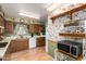 A functional kitchen featuring wood cabinets, white appliances, and laminate floors at 6337 E Evergreen St, Mesa, AZ 85205