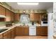 A functional kitchen featuring wood cabinets, white appliances, and laminate floors at 6337 E Evergreen St, Mesa, AZ 85205