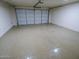A spacious garage featuring epoxy flooring and white walls, with a large garage door and plenty of room for storage at 6721 E Phelps Rd, Scottsdale, AZ 85254