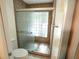 Updated shower featuring glass door, glass block window, and decorative tile surround at 6721 E Phelps Rd, Scottsdale, AZ 85254