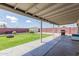 Spacious backyard featuring a covered patio, grassy area, fire pit, storage shed, and barbecue grill at 7235 W Flower St, Phoenix, AZ 85033
