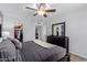 This primary bedroom features a ceiling fan, closet, and a dresser with a mirror at 7235 W Flower St, Phoenix, AZ 85033