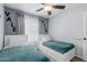 A gray bedroom with two beds, light hardwood floors, and white frames at 7235 W Flower St, Phoenix, AZ 85033
