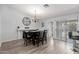 Bright dining room with wood-look floors, modern chandelier, and access to outdoor patio at 7235 W Flower St, Phoenix, AZ 85033
