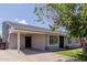 Single-story home with a covered carport and well-kept lawn, creating a welcoming curb appeal at 7235 W Flower St, Phoenix, AZ 85033