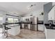 Bright kitchen features stainless steel appliances, breakfast bar, and wood-look floors at 7235 W Flower St, Phoenix, AZ 85033