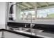 Close up of kitchen sink with black countertops and stainless steel faucet at 7235 W Flower St, Phoenix, AZ 85033