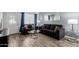 Well-lit living room featuring contemporary furniture, a large mirror, and stylish tile flooring at 7235 W Flower St, Phoenix, AZ 85033