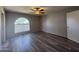 A bright bedroom with hardwood floors, arched window, and a modern ceiling fan at 8115 N 56Th Ave, Glendale, AZ 85302