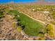 Scenic aerial view of a lush green golf course nestled within a desert landscape and mountain backdrop at 9270 E Thompson Peak Pkwy # 367, Scottsdale, AZ 85255