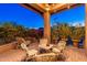 Inviting covered patio with cushioned seating, string lights, and lush landscaping provides a relaxing outdoor space at 9270 E Thompson Peak Pkwy # 367, Scottsdale, AZ 85255