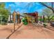 Community playground with a green slide, swings, and shade features for outdoor fun at 9270 E Thompson Peak Pkwy # 367, Scottsdale, AZ 85255