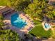 Aerial view of a community pool with lounge chairs, a splash pad, and lush landscaping at 9270 E Thompson Peak Pkwy # 367, Scottsdale, AZ 85255