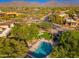 Aerial view of a community pool area, with mature trees, chairs, and mountain views in the distance at 9270 E Thompson Peak Pkwy # 367, Scottsdale, AZ 85255