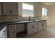 Kitchen counter and sink with gray cabinets, dark countertops, a gray tile backsplash, and two windows at 9539 W Parkway Dr, Tolleson, AZ 85353