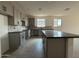 Spacious kitchen with gray cabinets, dark countertops, tile backsplash, and wood-look tile flooring at 9539 W Parkway Dr, Tolleson, AZ 85353