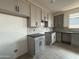 Kitchen featuring gray cabinets, dark counters, light walls, and light brown wood-look tile flooring at 9539 W Parkway Dr, Tolleson, AZ 85353