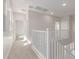 Upstairs hallway featuring carpeted floors, neutral walls, and white railing at 10229 N 49Th Dr, Glendale, AZ 85302