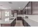 Open concept kitchen design with dark cabinets, quartz countertops, island, and stainless steel appliances at 10229 N 49Th Dr, Glendale, AZ 85302