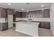 Modern kitchen with dark cabinets, a white island, stainless steel appliances, and tile backsplash at 10229 N 49Th Dr, Glendale, AZ 85302