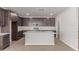Modern kitchen with dark cabinets, a white island, stainless steel appliances, and tile backsplash at 10229 N 49Th Dr, Glendale, AZ 85302