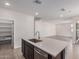 Gourmet kitchen island featuring stainless steel sink, quartz countertop, and walk-in pantry access at 10229 N 49Th Dr, Glendale, AZ 85302