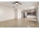 Open-concept living space with tile flooring, ceiling fan, and view of the kitchen and backyard at 1176 N 169Th Ave, Goodyear, AZ 85338
