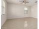 Spacious living room featuring tile floors, a ceiling fan, and ample natural light from large windows at 1176 N 169Th Ave, Goodyear, AZ 85338