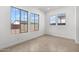 Empty bedroom showcasing tile flooring and large windows, providing great natural light at 12327 W Luxton Ln, Avondale, AZ 85323