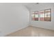 Small, light filled empty bedroom with large windows and tile floors at 12327 W Luxton Ln, Avondale, AZ 85323