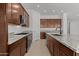 Updated kitchen with granite countertops, stainless steel appliances, and wooden cabinetry at 12327 W Luxton Ln, Avondale, AZ 85323