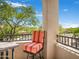 Balcony view with a comfortable striped chair and scenic tree-lined neighborhood views at 14850 E Grandview Dr # 204, Fountain Hills, AZ 85268