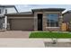 Beautiful single-Gathering home with a two-car garage, stone accents, green grass and a paver driveway at 22762 E Stacey Rd, Queen Creek, AZ 85142