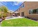 A beautiful, well-maintained backyard featuring a green lawn, patio with tables and umbrellas, and desert landscaping at 2565 E Southern Ave # 130, Mesa, AZ 85204