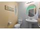 Charming powder room with beach decor, pedestal sink, and a unique round mirror at 2565 E Southern Ave # 130, Mesa, AZ 85204
