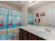 A well-lit bathroom featuring a flamingo shower curtain, single sink, and vanity at 2565 E Southern Ave # 130, Mesa, AZ 85204