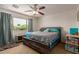 Cozy bedroom with a large window, ceiling fan, and a stylish, rustic-style bed at 2565 E Southern Ave # 130, Mesa, AZ 85204
