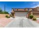 Tan two-story home with a two-car garage and desert landscaping at 2565 E Southern Ave # 130, Mesa, AZ 85204
