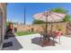 Cozy backyard patio area with an umbrella-covered table, chairs, and green lawn at 2565 E Southern Ave # 130, Mesa, AZ 85204