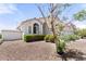Charming single-story home featuring mature landscaping with gravel, an American flag, and an arched window at 2821 E Pontiac Dr, Phoenix, AZ 85050